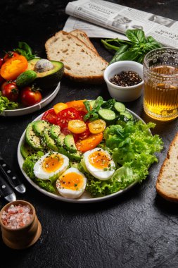 Avokado, yumurta, domates ve salatalıklı sağlıklı salata kasesi.,