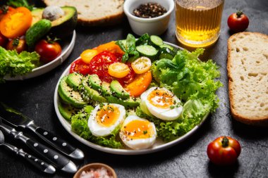 Avokado, yumurta, domates ve salatalıklı sağlıklı salata kasesi.,