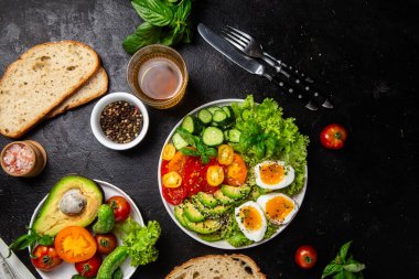 Avokado, yumurta, domates ve salatalıklı sağlıklı salata kasesi.,