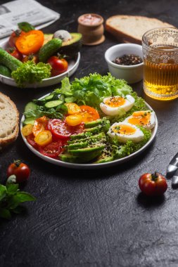 Avokado, yumurta, domates ve salatalıklı sağlıklı salata kasesi.,