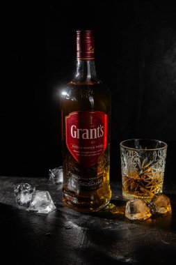 Karanlık arka planda bir şişe Grant 's Whiskey. 