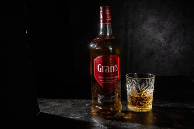 Karanlık arka planda bir şişe Grant 's Whiskey. 