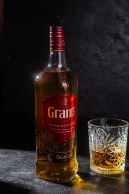 Karanlık arka planda bir şişe Grant 's Whiskey. 