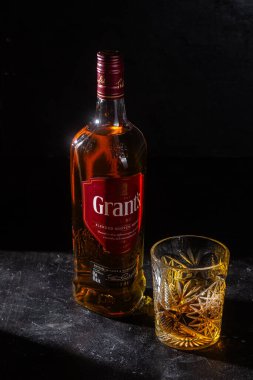 Karanlık arka planda bir şişe Grant 's Whiskey. 