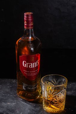 Karanlık arka planda bir şişe Grant 's Whiskey. 