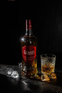 Karanlık arka planda bir şişe Grant 's Whiskey. 