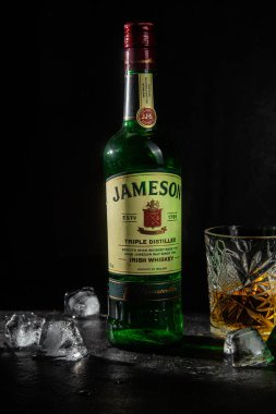  Karanlık bir arka planda bir şişe viski Jameson.