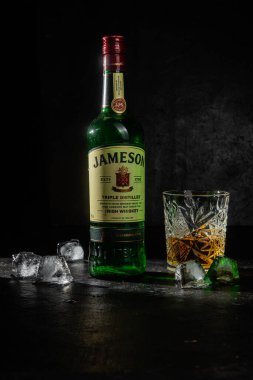  Karanlık bir arka planda bir şişe viski Jameson.