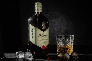 Siyah arka planda bir şişe Ballantine 's Whiskey.