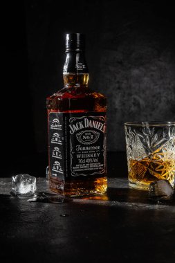 Karanlık bir arka planda bir şişe viski.
