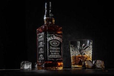 Karanlık bir arka planda bir şişe viski.