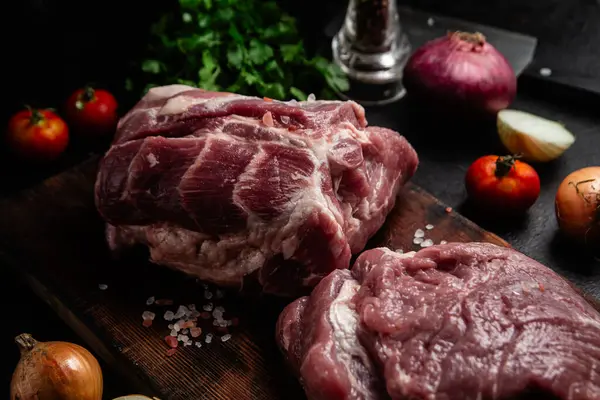 Masadaki tahta tahtada çiğ domuz boynu.