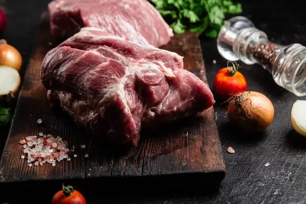 Masadaki tahta tahtada çiğ domuz boynu.