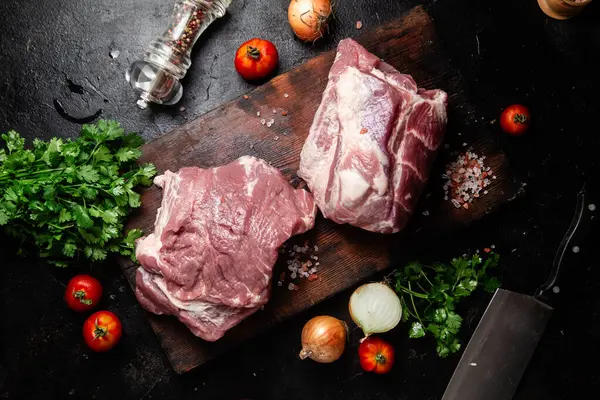 Masadaki tahta tahtada çiğ domuz boynu.