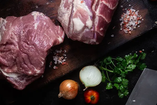 Masadaki tahta tahtada çiğ domuz boynu.