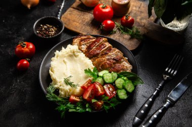 Patates püresi ve salatayla servis edilen leziz ızgara tavuk göğsü dilimleri.