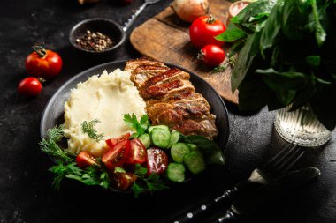 Patates püresi ve salatayla servis edilen leziz ızgara tavuk göğsü dilimleri.