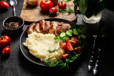 Patates püresi ve salatayla servis edilen leziz ızgara tavuk göğsü dilimleri.