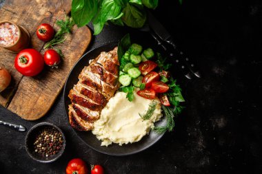 Patates püresi ve salatayla servis edilen leziz ızgara tavuk göğsü dilimleri.