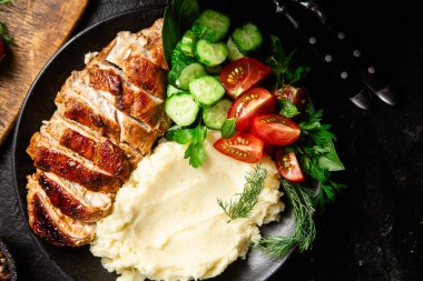 Patates püresi ve salatayla servis edilen leziz ızgara tavuk göğsü dilimleri.