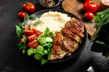 Patates püresi ve salatayla servis edilen leziz ızgara tavuk göğsü dilimleri.