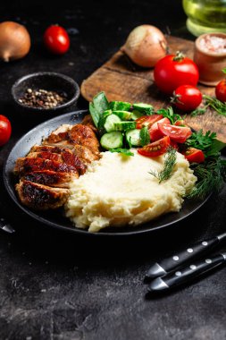 Patates püresi ve salatayla servis edilen leziz ızgara tavuk göğsü dilimleri.