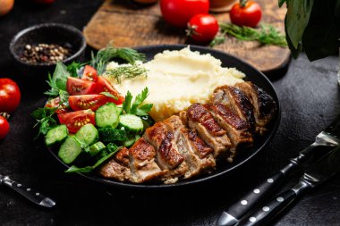 Patates püresi ve salatayla servis edilen leziz ızgara tavuk göğsü dilimleri.