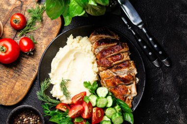 Patates püresi ve salatayla servis edilen leziz ızgara tavuk göğsü dilimleri.