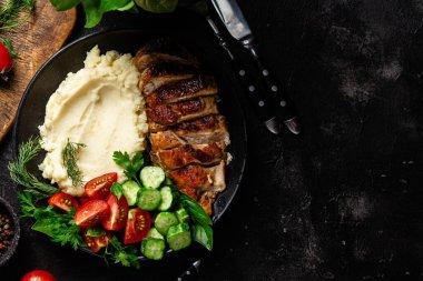 Patates püresi ve salatayla servis edilen leziz ızgara tavuk göğsü dilimleri.