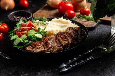 Patates püresi ve salatayla servis edilen leziz ızgara tavuk göğsü dilimleri.