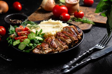 Patates püresi ve salatayla servis edilen leziz ızgara tavuk göğsü dilimleri.