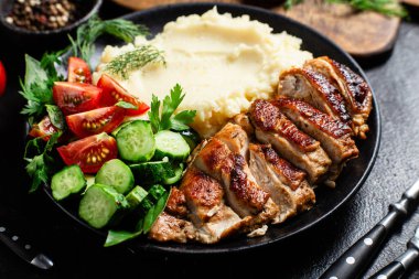 Patates püresi ve salatayla servis edilen leziz ızgara tavuk göğsü dilimleri.