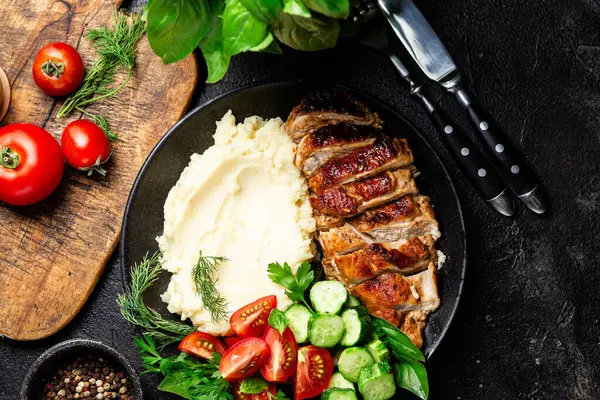 Patates püresi ve salatayla servis edilen leziz ızgara tavuk göğsü dilimleri.