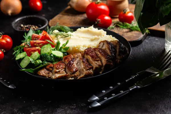 Patates püresi ve salatayla servis edilen leziz ızgara tavuk göğsü dilimleri.