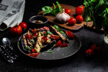 Siyah tabakta patlıcan, domates ve fesleğen salatası.