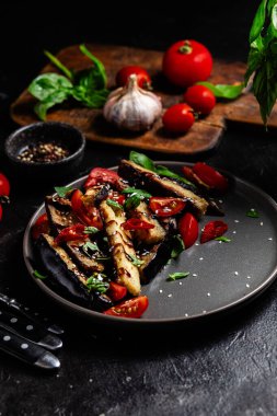 Siyah tabakta patlıcan, domates ve fesleğen salatası.