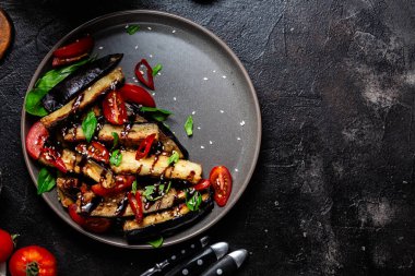Siyah tabakta patlıcan, domates ve fesleğen salatası.