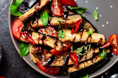 Siyah tabakta patlıcan, domates ve fesleğen salatası.