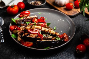 Siyah tabakta patlıcan, domates ve fesleğen salatası.