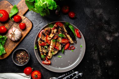 Siyah tabakta patlıcan, domates ve fesleğen salatası.