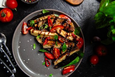 Siyah tabakta patlıcan, domates ve fesleğen salatası.