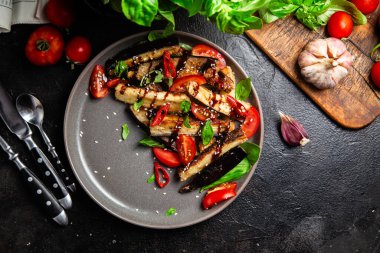 Siyah tabakta patlıcan, domates ve fesleğen salatası.