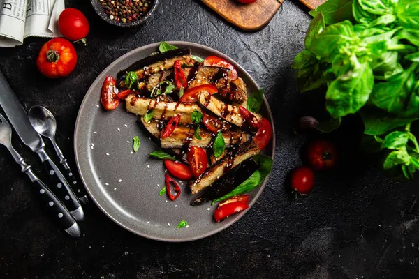 Siyah tabakta patlıcan, domates ve fesleğen salatası.