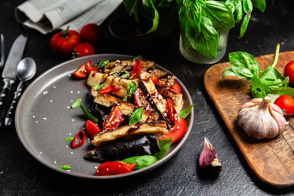 Siyah tabakta patlıcan, domates ve fesleğen salatası.