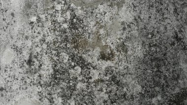 Koyu lekeleri ve düz olmayan yüzeyi olan pürüzlü beton doku..
