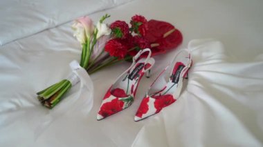 SAINT-PETERSBURG, RUSSIA - 8 AĞUSTOS 2023: Bir buket beyaz ve kırmızı çiçek ve bir kadın ayakkabısı. Düğün günü gelin aksesuarları. Dolce ve Gabbana. Gelinlik.