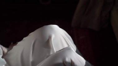 Young girl in a white robe sits on chair with hands. Unrecognizable woman. The bride on the wedding morning. Romance.
