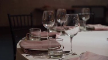 Gözlüklü ve tabaklı bir düğün resepsiyonu için masa ayarlama. Kapalı resepsiyon salonu.