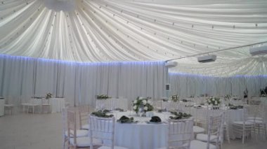 Çok güzel dekore edilmiş bir düğün resepsiyonu salonu. Masalı, sandalyeli, çiçekli bir oda. Lüks etkinlik.
