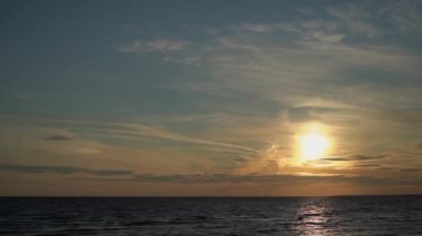 Denizde gün batımı ya da gün doğumu. Plaj tatili romantik şafak. Doğada bir akşam. Dramatik gökyüzü ve sudaki yansımalar.
